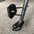 Arenzza motorcycle kickstand foot extension for side stand, showing the metal extension piece on a motorcycle side stand.