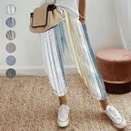 A woman wearing striped linen cotton trousers by Arenzza, showcasing effortless style and comfort in a casual outdoor setting.