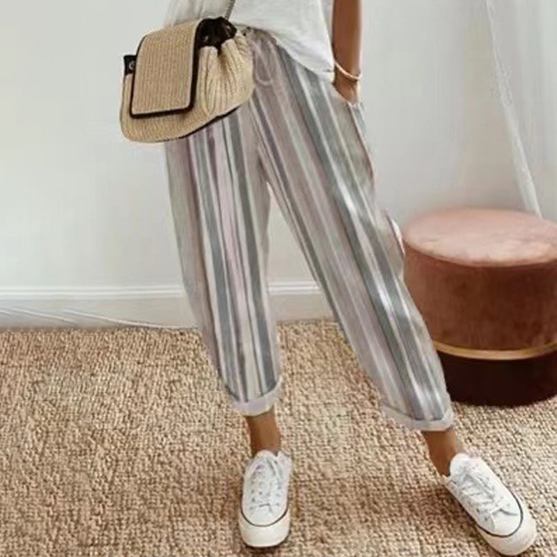 A woman wearing striped linen cotton trousers by Arenzza, showcasing effortless style and comfort in a casual outdoor setting.