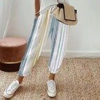A woman wearing striped linen cotton trousers from Arenzza, showcasing effortless style and comfort in a casual outfit.