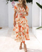 A women's floral square neck puff sleeve smocked tiered dress by Arenzza, featuring short sleeves and a vibrant summer floral pattern.
