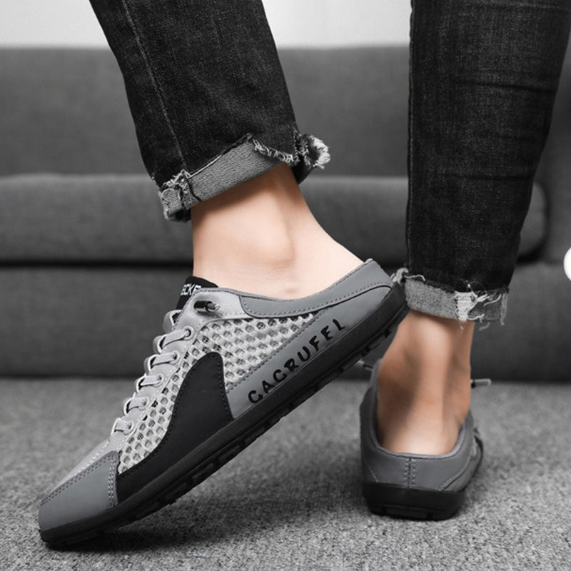 A pair of Arenzza men's breathable mesh slip-on half slippers with open toes and cushioned soles, ideal for comfortable indoor wear.
