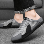 A pair of men's breathable mesh slip-on half slippers by Arenzza, shown in a close-up view highlighting the soft mesh material.
