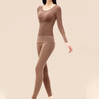A woman wearing Arenzza thermal underwear set for women, showcasing the long-sleeve top and matching thermal pants in a cozy indoor setting.