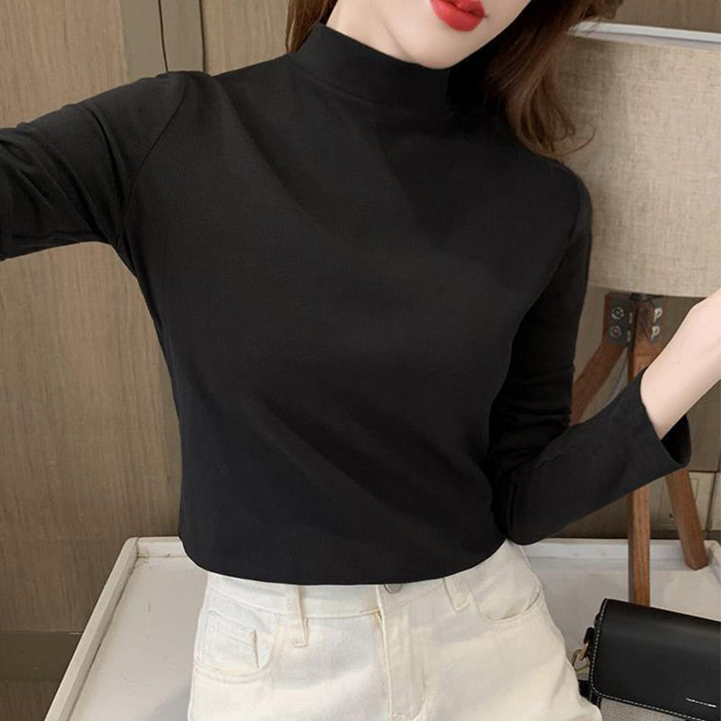 A women’s solid color half high neck long sleeve top by Arenzza, displayed on a hanger, showcasing its comfortable fit and stylish design.