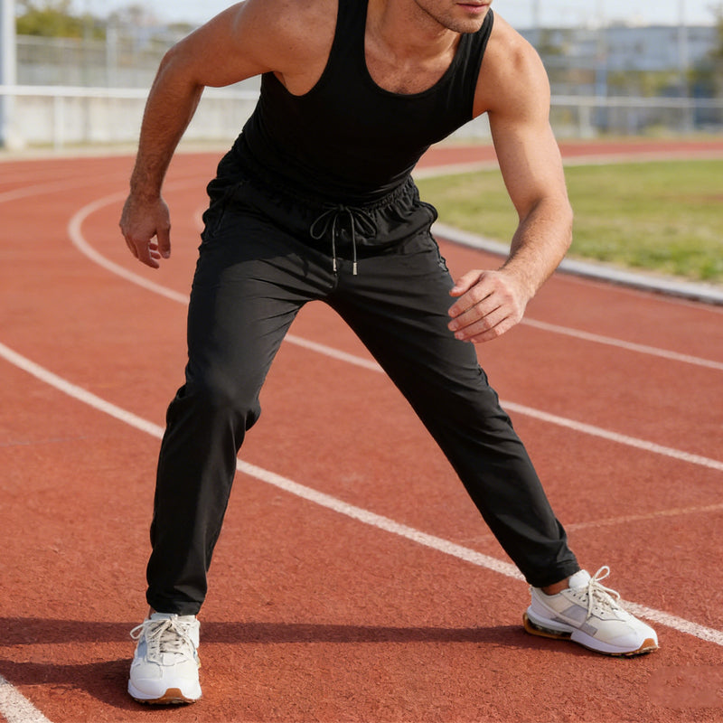 A pair of men's lightweight athletic pants with zipper pockets by Arenzza, shown lying flat with front view.