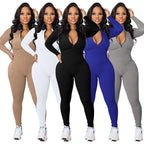 A black Arenzza solid color half zip seamless jumpsuit with long sleeves and fitted design, displayed on a hanger.