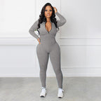 A beige solid color half zip seamless jumpsuit by Arenzza, made of stretchy, smooth fabric, displayed on a hanger.