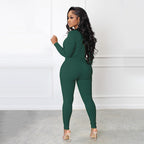 A woman wearing a green Arenzza solid color half zip seamless jumpsuit, showing the fitted design and high neckline.