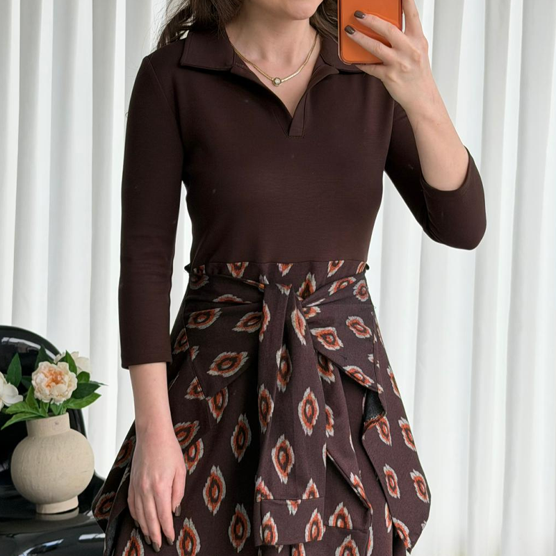 A Arenzza tie-waist fit and flare midi dress with a sleeveless design and elegant silhouette, shown hanging on a white background.