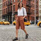 A woman wearing Arenzza women's casual drawstring capri shorts, lightweight denim with rolled cuffs and side pockets.