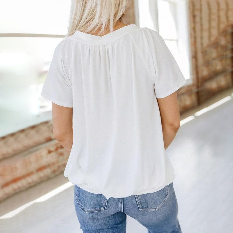 A woman wearing a beige Arenzza women's casual pleated V-neck short-sleeve top, showcasing the relaxed fit and stylish design.