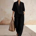 A woman wearing a women's casual V-neck top and wide-leg pants set by Arenzza, featuring a relaxed fit and stylish design.