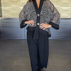 A woman wearing a women's V-neck sequin cardigan and wide-leg pants from Arenzza, stylish and elegant 2-piece clothing set.