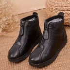 A pair of Arenzza women's winter ankle boots with side zippers, thermal insulation, water-resistant material, shown on a model.