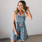 A vintage floral printed denim jumpsuit by Arenzza featuring a stylish design and colorful floral pattern on denim fabric.