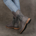 A pair of Arenzza women’s lace-up low-heel ankle boots with round toes in black leather, stylish and comfortable footwear.