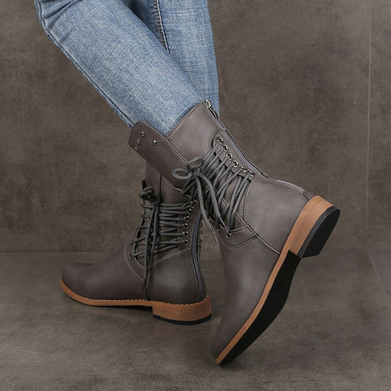 A pair of Arenzza women’s lace-up low-heel ankle boots with round toes in black leather, stylish and comfortable footwear.