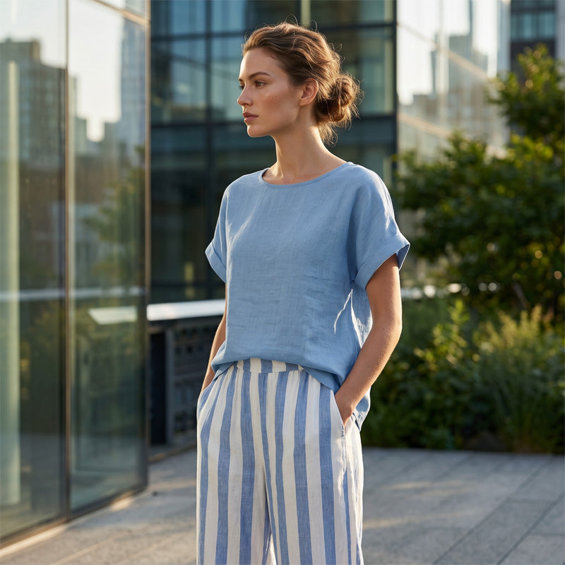A woman wearing a casual solid top and striped wide-leg pants by Arenzza, showcasing effortless weekend style.