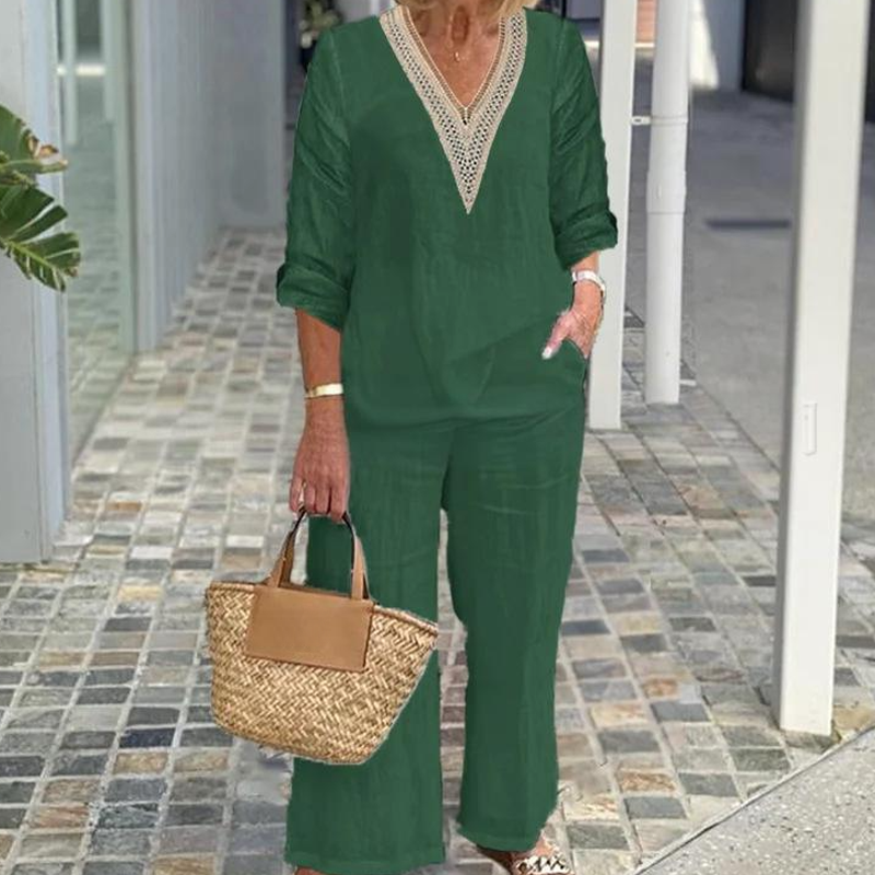 A woman wearing a white V-neck top and wide-leg pants from Arenzza, stylish casual outfit, close-up of the clothing ensemble.