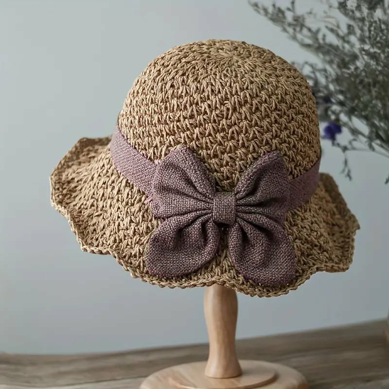 A woven straw sun hat with a bow from Arenzza, featuring a wide brim and stylish design for sun protection and fashion.