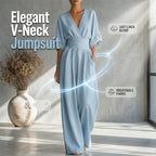 A woman wearing a white high waist wide-leg jumpsuit by Arenzza with V-neck design, styled casually indoors.