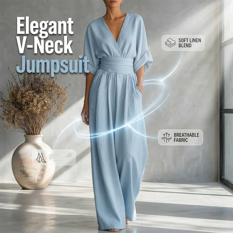 A woman wearing a white high waist wide-leg jumpsuit by Arenzza with V-neck design, styled casually indoors.