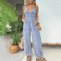 A woman wearing a blue denim jumpsuit with a deep V-neck, from Arenzza, casual clothing fashion for women.