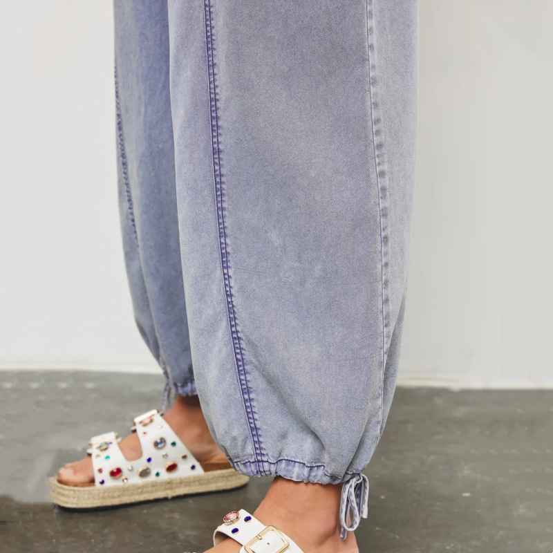 Aarenza women's deep V-neck denim jumpsuit, stylish casual clothing with long sleeves and fitted waist, on a model.