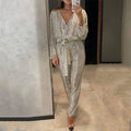 Aarenza women's sparkly V-neck belted jumpsuit, featuring a shiny fabric, V neckline, and a waist belt, displayed on a hanger.