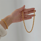 Layered gold twist rope necklaces and bracelets from Arenzza, featuring elegant, intertwined jewelry pieces for stylish accessorizing.