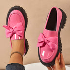 A pair of Arenzza chic purple platform loafers with bows, stylish footwear for women, displayed on a neutral background.