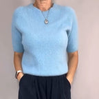 A woman wearing a beige knit top and loose wide-leg pants set by Arenzza, showcasing comfortable, stylish loungewear.