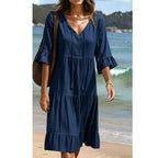 A women's V-neck tassel tie tiered midi dress by Arenzza, featuring a flowy silhouette and layered fabric in a stylish design.