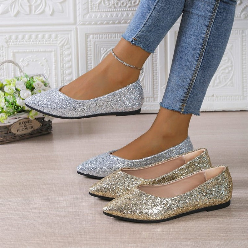 A pair of women's glitter pointed toe flats by Arenzza with a shiny, sparkling surface and sleek design, perfect for stylish footwear.
