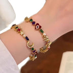 Arenzza celestial charm bracelet with whimsical star and moon designs, set against a neutral background.