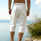 A men's linen blend cargo capri pants by Arenzza, featuring multiple pockets and a relaxed fit, displayed on a hanger.