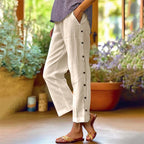 A pair of Arenzza casual solid-color loose-fit cropped pants with side buttons, displayed on a hanger.