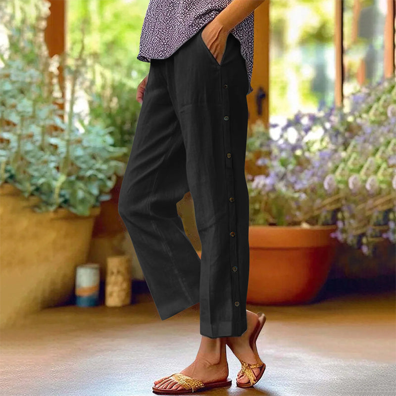 A pair of Arenzza casual solid-color loose-fit cropped pants with side buttons, shown on a model highlighting relaxed style and fit.