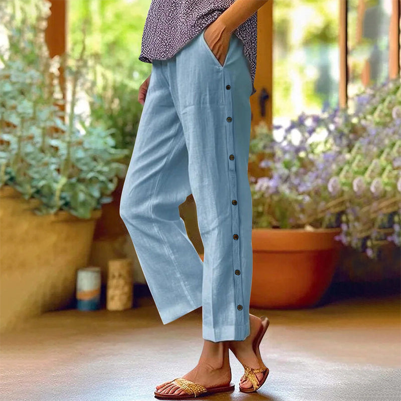 A pair of Arenzza casual solid-color loose-fit cropped pants with side buttons, displayed on a hanger.