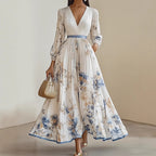 A woman wearing an elegant V-neck floral pleated maxi dress by Arenzza, showcasing a flowing design with vibrant floral patterns.