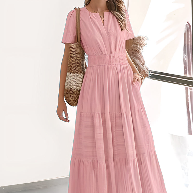 A woman wearing a boho chic smocked waist maxi dress by Arenzza, featuring floral patterns and flowing fabric.