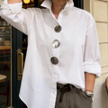 A woman wearing an oversized Arenzza women's button-down shirt with bold statement buttons, showcasing relaxed fit and stylish details.