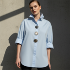 A woman wearing an oversized Arenzza women's button-down shirt with statement buttons, showcasing the relaxed fit and stylish design.