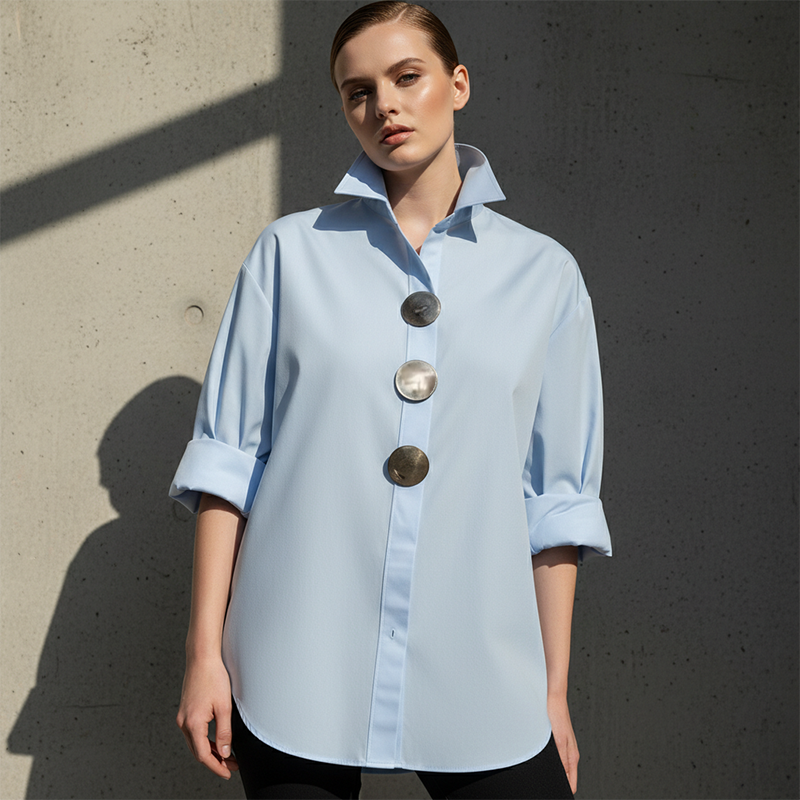 A woman wearing an oversized Arenzza women's button-down shirt with statement buttons, showcasing the relaxed fit and stylish design.