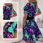 A woman wearing a floral print V-neck mini dress by Arenzza, perfect for summer, with bright colors and a flowy design.