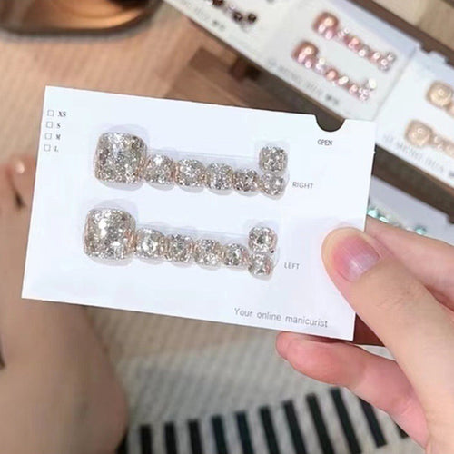 A collection of 14 square press-on toenail sheets by Arenzza, showcasing neatly arranged, adhesive cosmetic toenail extensions.