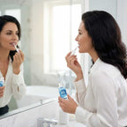 A person smiling with bright teeth, holding BrightSmile™ peroxide-free teeth whitening product by Arenzza in a lifestyle setting.