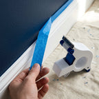 Arenzza masking tape applicator tool held in hand, used for precise, clean masking tape application on a DIY project.