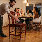 A person placing SlideSafe™ protectors under furniture legs to prevent scratches and noise, in a modern home setting.